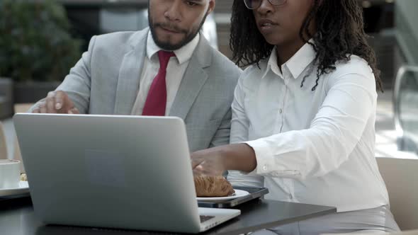 Cheerful Colleagues Discussing Business Questions at Cafe alt