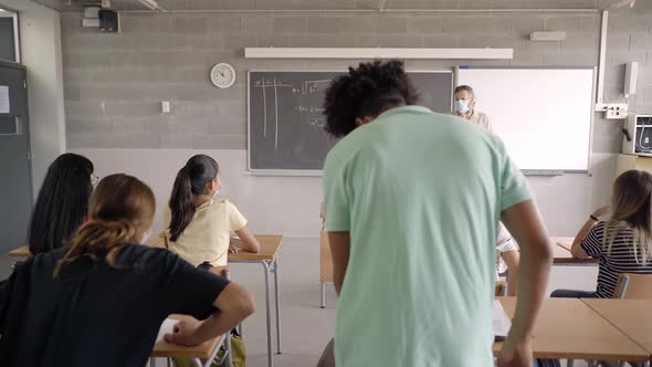 At Back to School the Teacher and Students Wear Protective Masks Due to the Coronavirus Pandemic alt