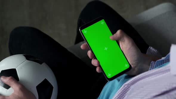Football Fan Use Smartphone at Home with Green Chroma Key Screen