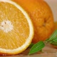 Slices of Fresh Orange with Leaves Slowly Rotate