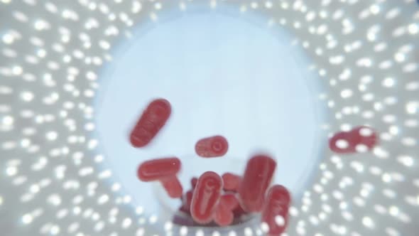 Red Capsules Of The Medication Is Falling Down Into The Camera 2