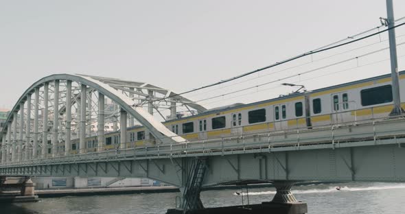 Tokyo Subway Passing By on a Bridge at Sunny Day, Water Transport and Flying Birds