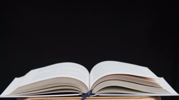 The Pages of the Open Book are Turning on Their Own in Slow Motion CloseUp alt
