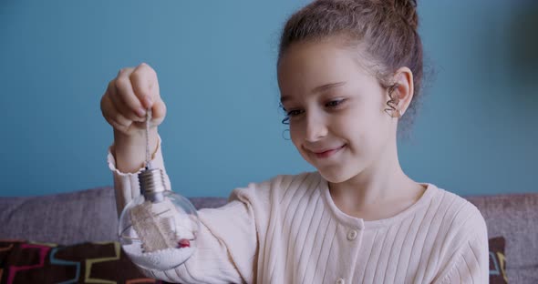 Portrait Funny Little Girl Smiling Child Looking at a Toy Ball are Sitting on Couch at Home Cute Kid alt