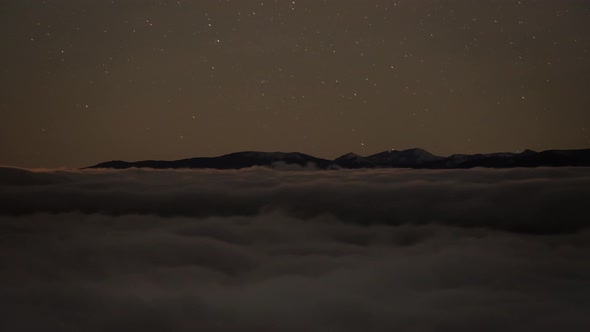 Time Lapse of Fog and Stars During the Night with Mountains in the Background 