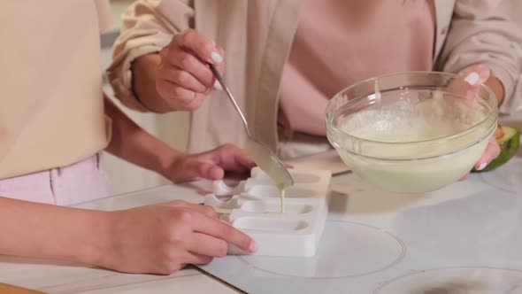 Pouring Ice Cream Mixture Into Forms alt