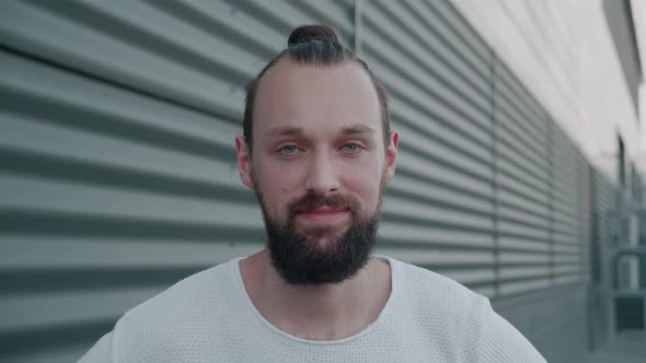 Close Up of Cheerful Male Hipster with Beard Looking to Camera and Smiling alt