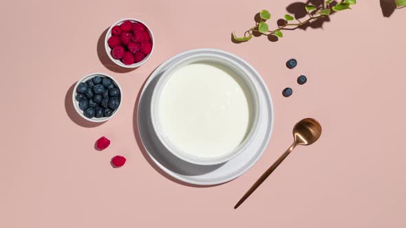 Smoothie bowls with granola, blueberries and raspberries on a pink background. Healthy breakfast ste alt