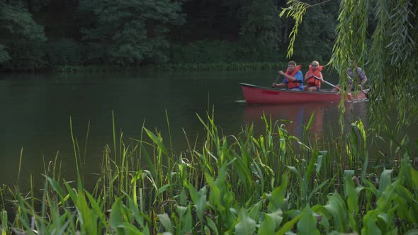 Kids at summer camp paddling canoe in pond
