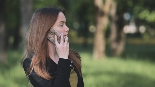A Young Student Talking on the Phone in the Park