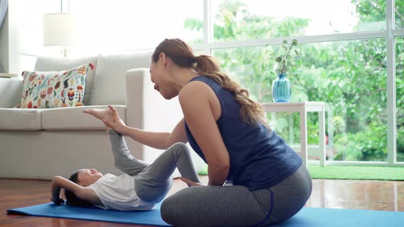 Asian Mother Practicing Yoga With Her Daughter  alt