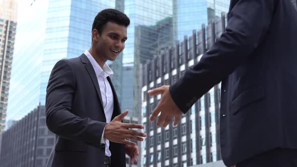 Indian businessman giving handshake to his business partner