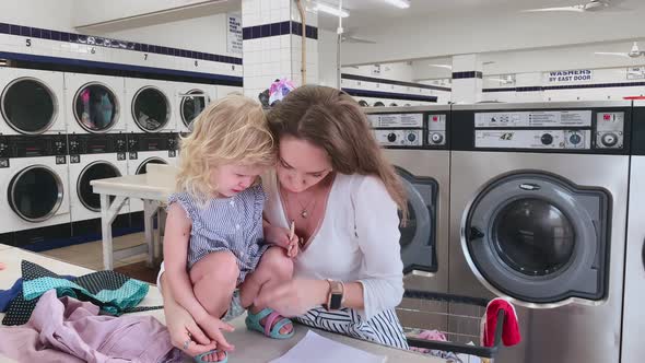 Tracking of Adorable Toddler Boy with Blond Hair Walking Barefoot on Green Grass Towards Young