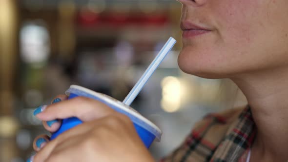 Young Woman Enjoying a Drink with the Straw. Drinking Cola or Soda Pop with a Straw. Close Up
