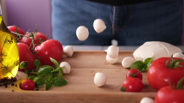 Mozzarella Cheese Small Balls Falling on Wooden Cutting Board alt