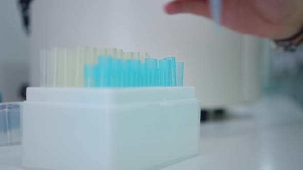 Closeup Box in Laboratory with Female Caucasian Hand Inserting Test Tube alt