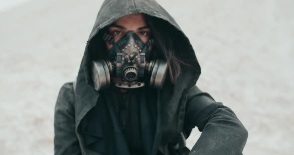 Portrait Post Apocalyptic Brunette Woman Wearing Grunge Hooded Mantle Protective Gas Mask in Desert alt