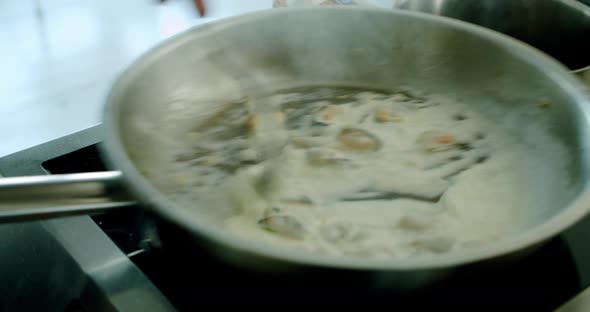 Mussels Fried on a Large Roasting Pan Boil and Steam Comes From Them alt