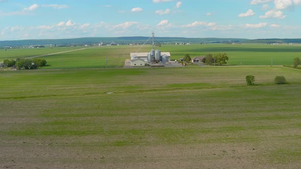 Silo and farmlands in a rural area of Canada, aerial stock footage.