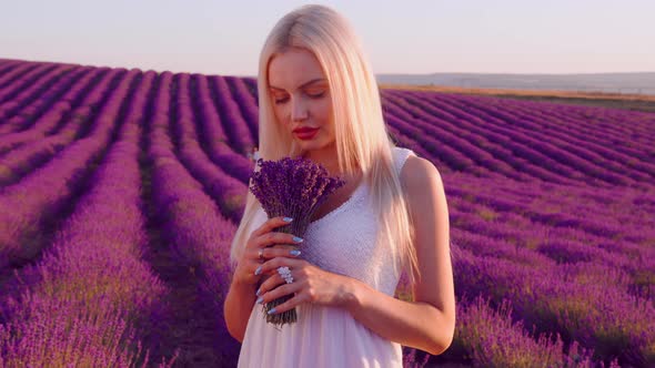 Blonde Woman Holding Bouquet of Lavender in Lavender Field