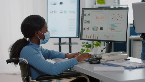 Invalid African Employee with Medical Face Mask Discussing with Coworker alt