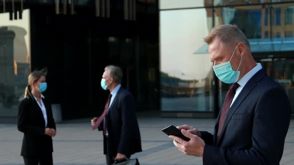 Boss in Protective Face Masks Gives Instructions To Subordinates on the Phone Team Management During