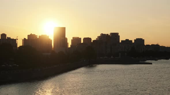 Sunset Over Embankment of Big City with Silhouettes of Multi-storey Buildings alt