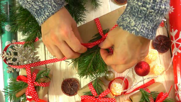 Woman is Wrapping Christmas Presents on the Table Concept of Preparing for the New Year and alt