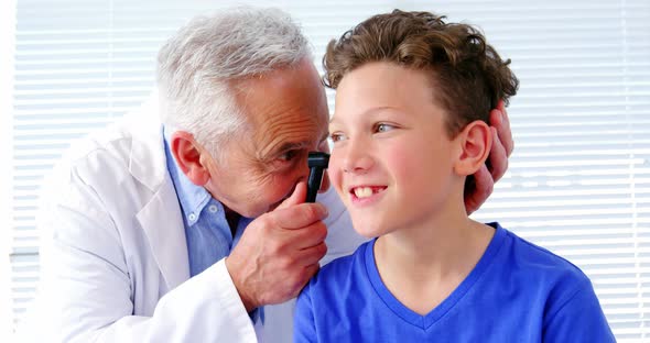 Male doctor examining a patients ear with horoscope, Stock Footage