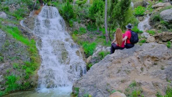 Man and Woman is Sitting on a Stone and Hugging alt