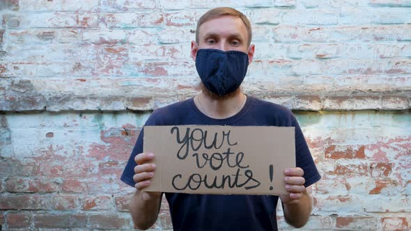 Man shows cardboard with Your Vote Counts sign Make the political choice Presidential elections 4K alt