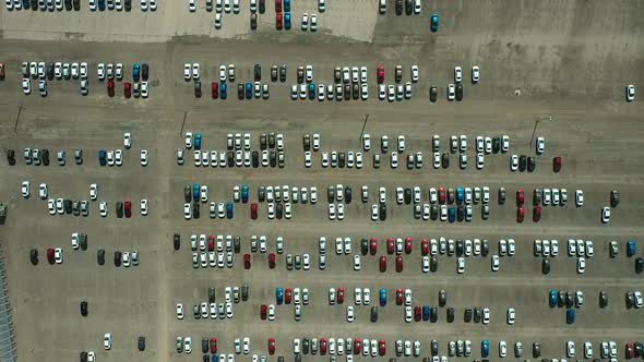 Many Cars Are Parked in a Large Asphalt Parking Lot. Cars Are Lined Up in a Huge Parking Lot. Aerial