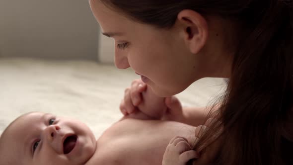 Authentic Close Up Shot Young Neo Mother Mum is Playing with Nake Newborn Child Baby on White Soft alt