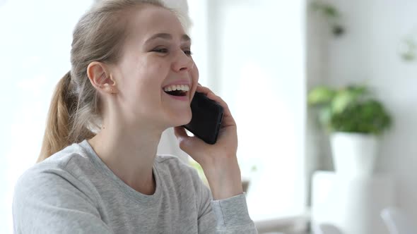 Young Woman Talking on Phone in Loft Workplace alt