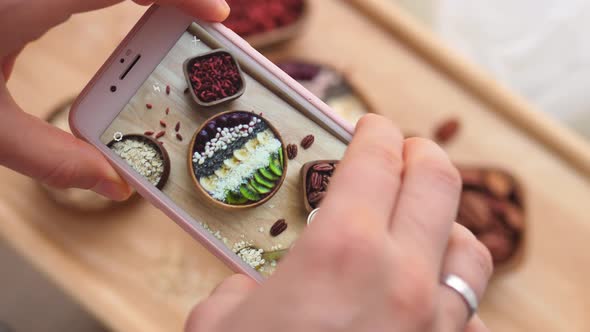Woman Hands Taking Photos Of Vegan Breakfast Using Smart Phone.  alt
