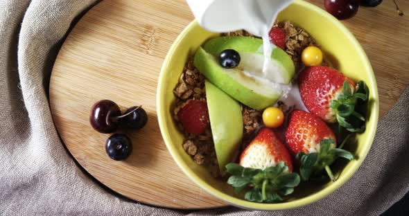 Milk being poured on a healthy breakfast 4k alt