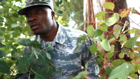 Military soldier looking around in park alt