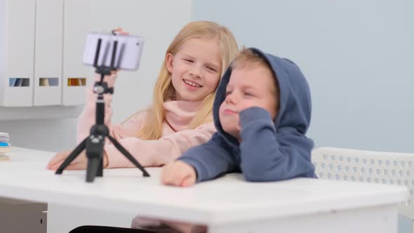 Kids Bloggers Talking with Followers Live Streaming Looking to Smartphone Screen at Home alt