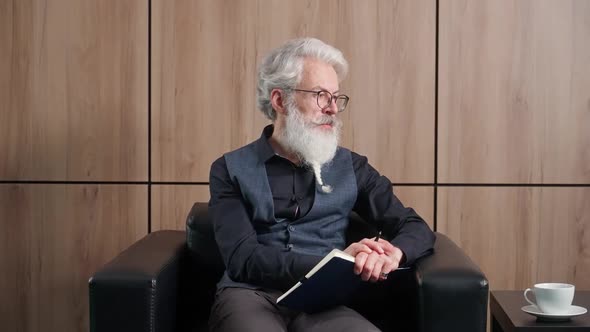 Grayhaired Man Designer Works in the Office Art Director Writes Down Ideas and Concepts in a alt