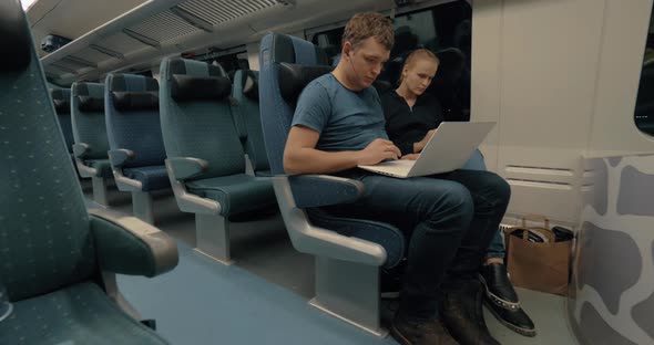 Commuters with Laptop and Cell in Train alt