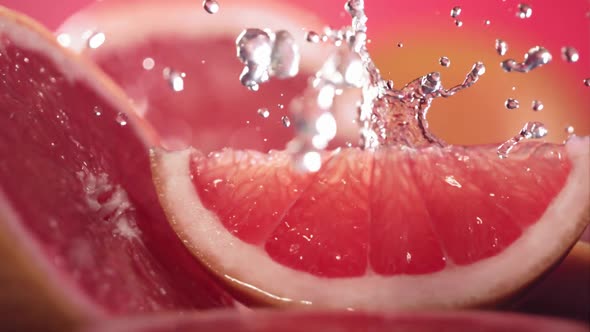 Slow Motion Shot of Grapefruit Water Splashing Through Grapefruit Slices alt