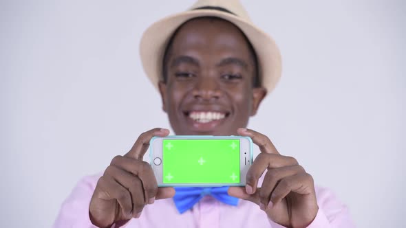 Face of Young Happy African Tourist Man Showing Phone alt
