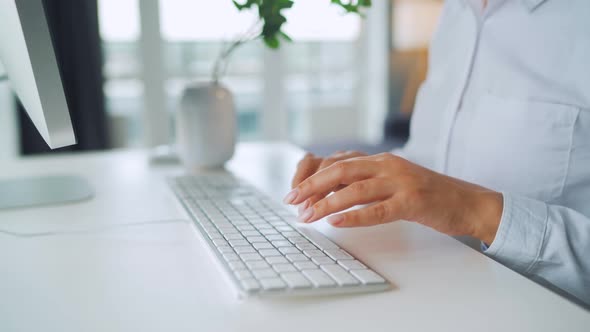 Woman with Glasses Typing on a Computer Keyboard. Concept of Remote Work. alt