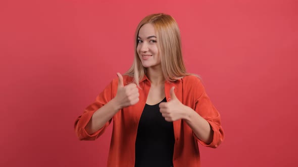 Beautiful Woman Showing Thumbs Up Gesture, Isolated on a Red Background alt