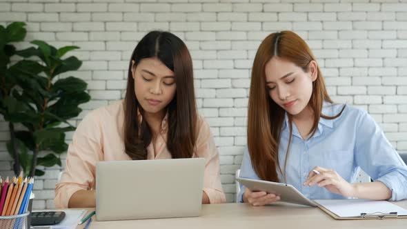 Happy entrepreneur asian business woman using smartphone laptop dealing negotiate with customer
