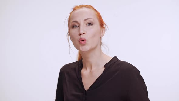 Beautiful Caucasian Female with Colored Orange Hair Whistling and Waiting on White Background alt