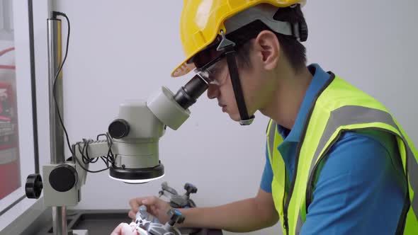 Factory engineers are using microscopes to inspect small specimens