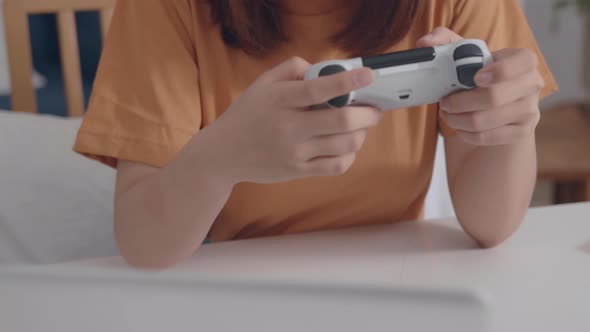 Close up shot of female hand holding white joystick playing a video game in