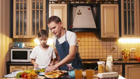 Caucasian father and son cooking sandwiches together