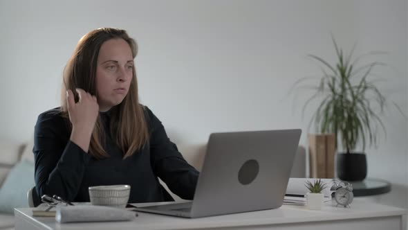Angry female freelancer typing on laptop computer at home. alt